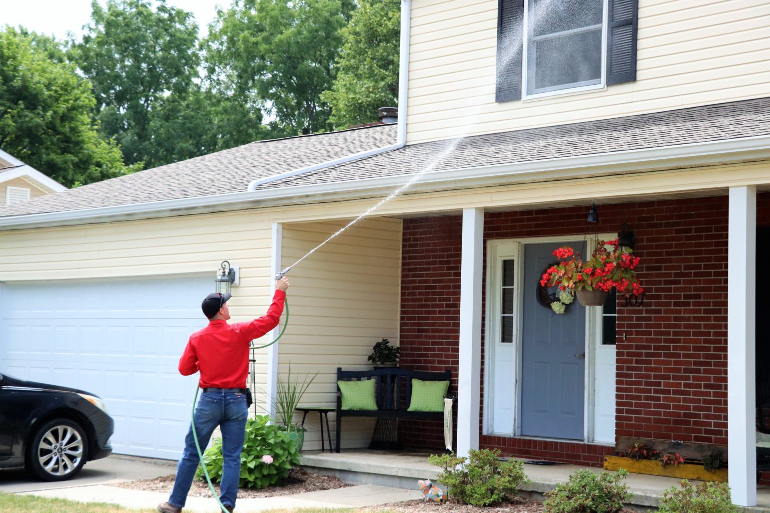 Reliance Pest Control technician treating the outside of a home